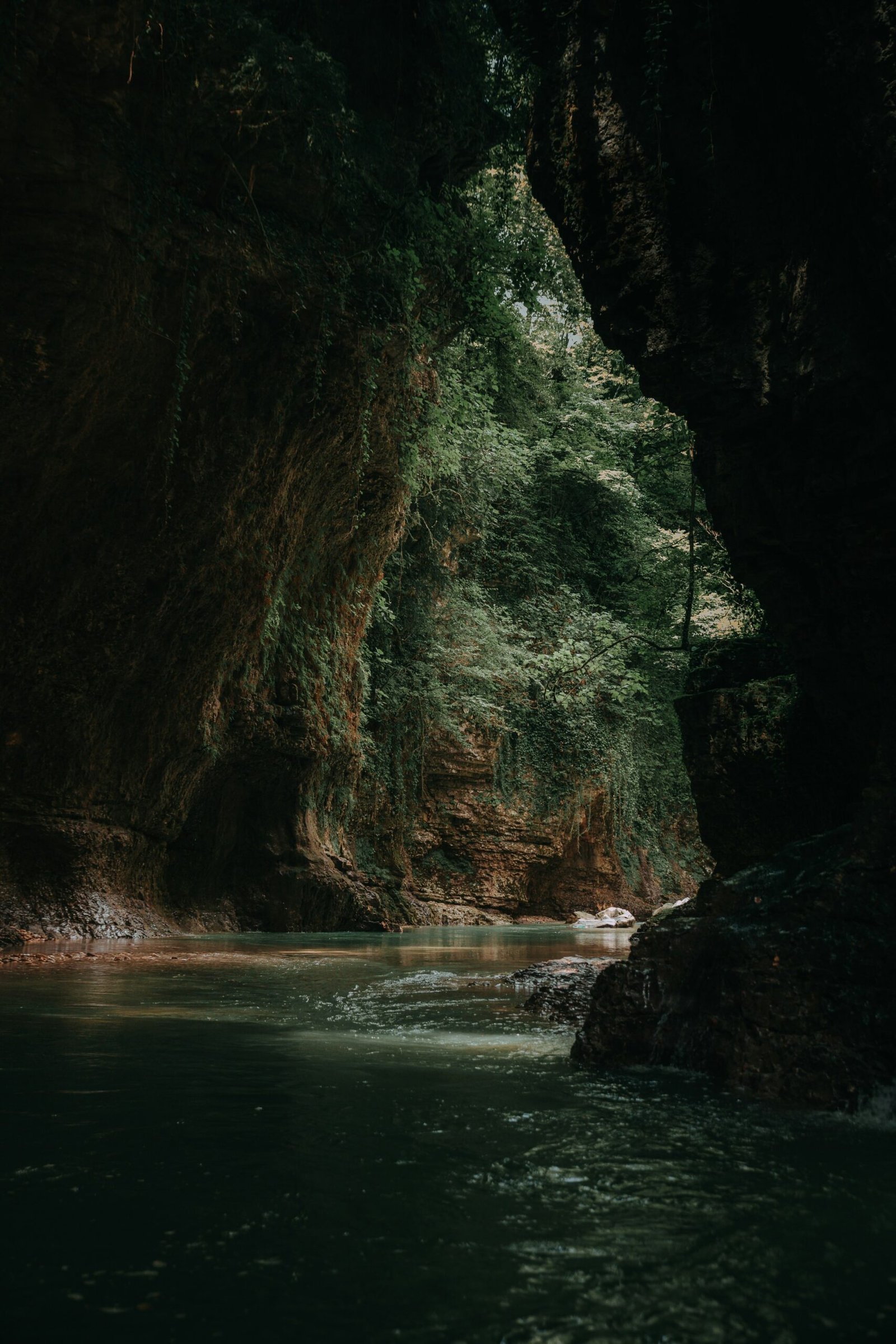 calm body of water inside cave at daytime